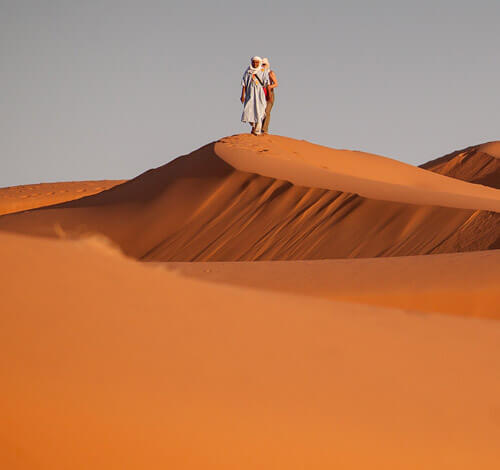 Pareja sobre una duna del desierto del sahara