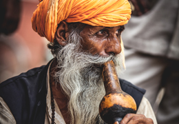 Hombre hindu tocando un instrumento | Colombian Tourist