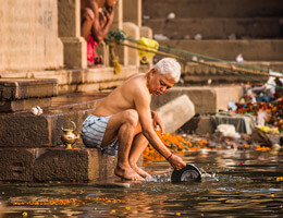 Hombre hindu tomando un baño en uno de los balneareos de los templos en la india