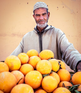 Imagen de un hombre vendiendo u ofreciendo frutas