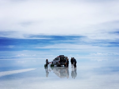 Grupo de personas reunidos en una camioneta que esta sobre el hielo | Colombian Tourist
