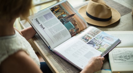 Mujer leyendo un libro sobre una mesa | Colombian Tourist