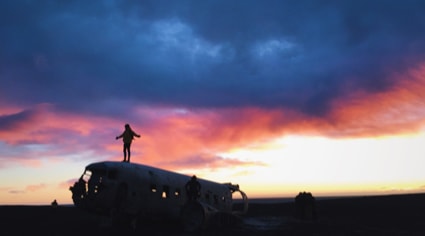 Jovenes sobre la carcaza de un avion sol de media noche | Colombian Tourist