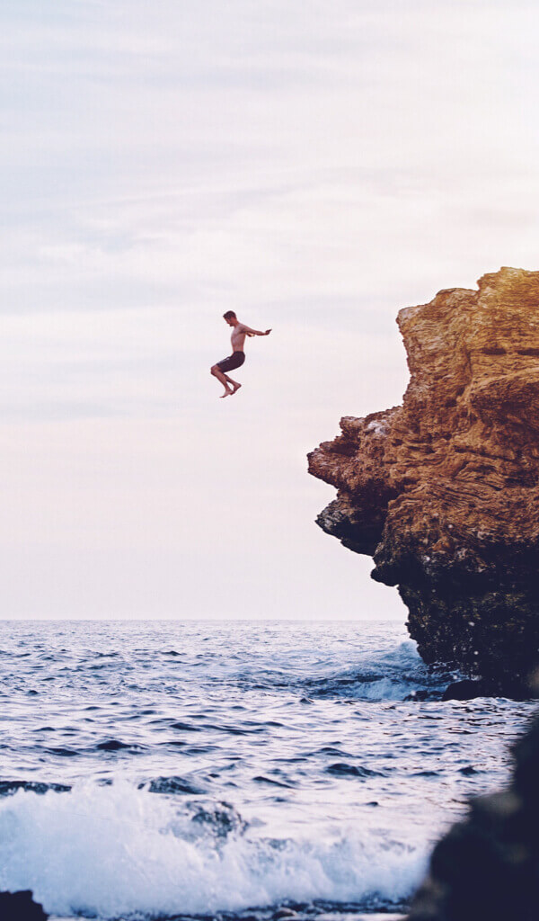 Imagen de joven tirandose al mar desde una roca alta Colombian Tourist