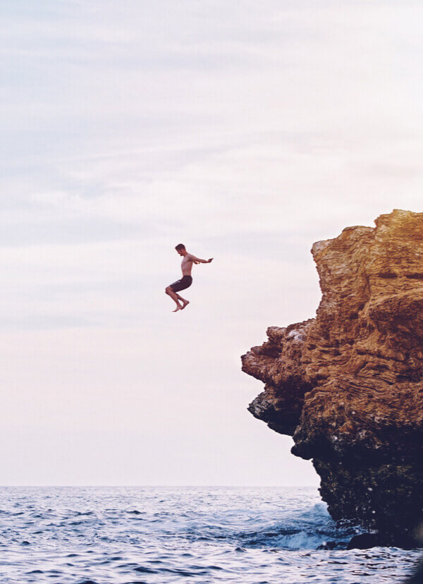 Imagen de joven tirandose al mar desde una roca alta Colombian Tourist